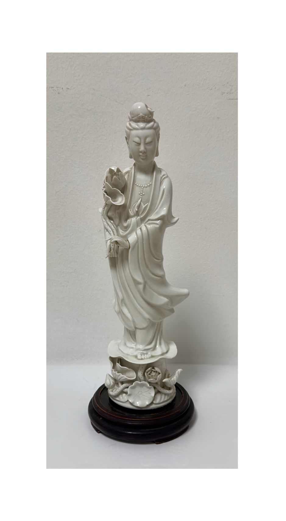 Scultura in porcellana Blanc de Chine, raffigurante He Xiangu che sorregge un grande fiore di loto.